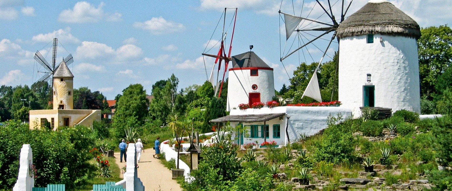 Traditionelle Windmühlen in einer grünen Umgebung an einem sonnigen Tag.