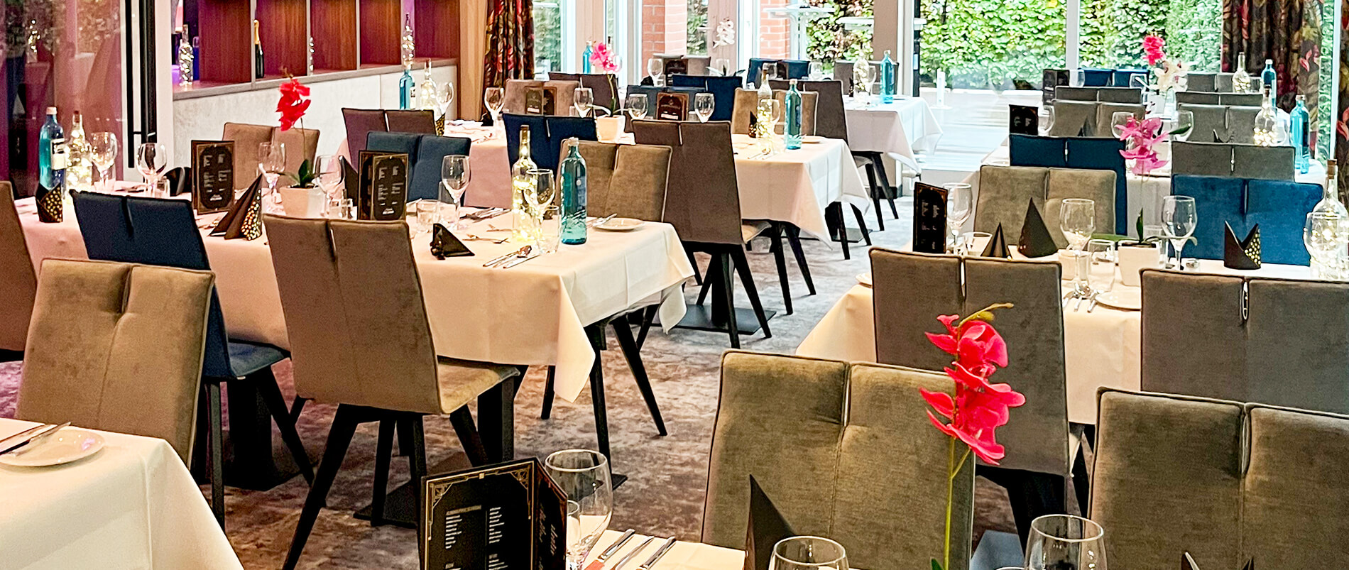 Elegantes Restaurant mit gedeckten Tischen und dekorativen Blumen