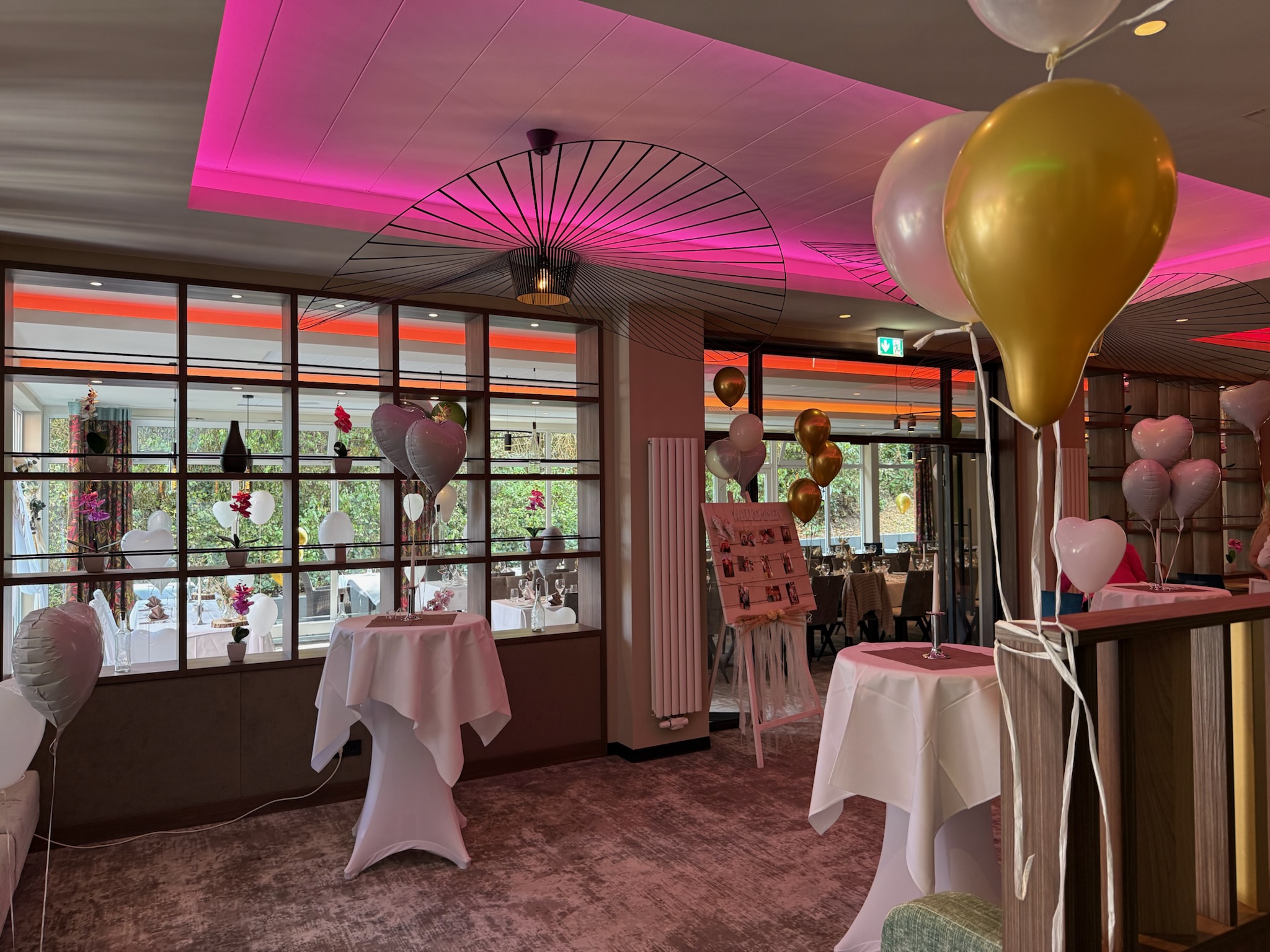 ein geschmückter Raum mit vielen Luftballons und Stehtischen im MORADA Hotel Gifhorn.