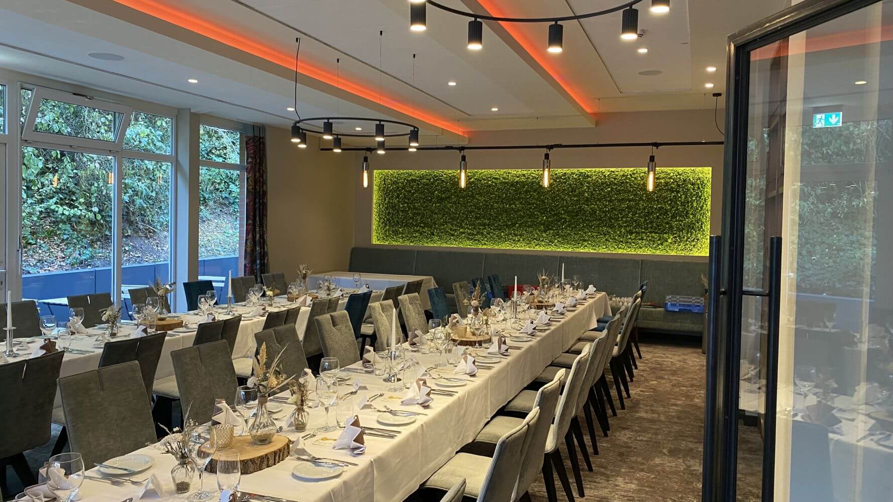 Elegantes Hotelrestaurant mit gedeckten Tischen und modernen Leuchten.