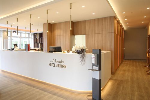 Rezeption des Morada Hotel Gifhorn mit modernem Design und freundlicher Atmosphäre.