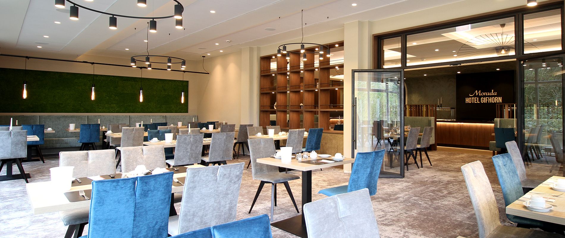 Modern eingerichteter Hotelrestaurant-Bereich mit gedeckten Tischgruppen, offener Raumgestaltung und eleganten Beleuchtungselementen.